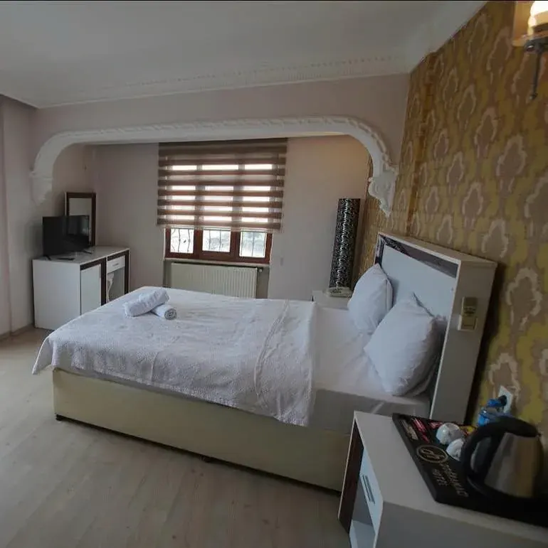 Deluxe Room: bed, TV unit and window