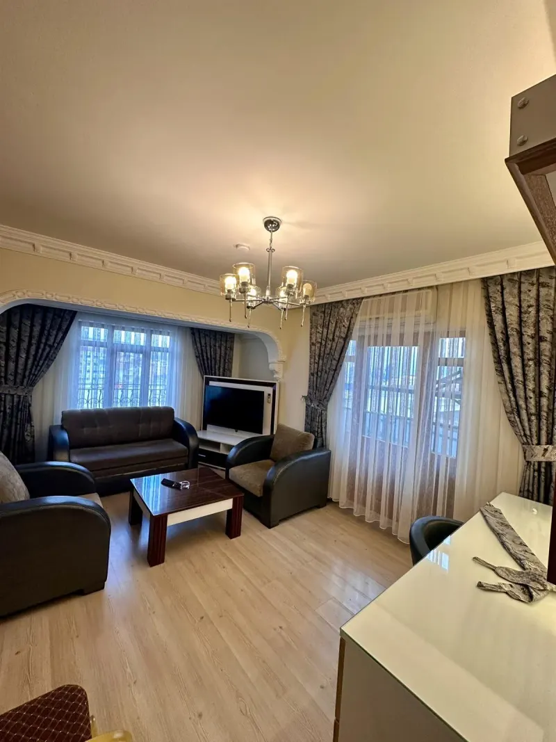 The separate sitting area of the King Suite with sofas, a TV and a chandelier