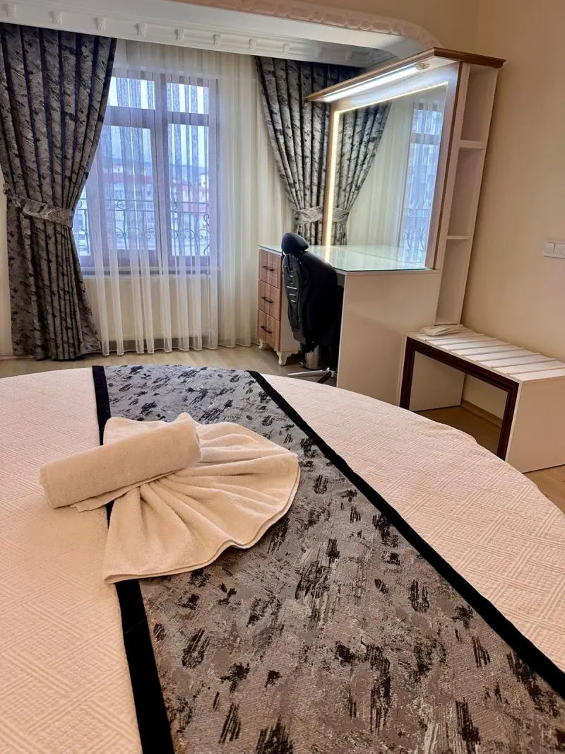 King Suite: a folded towel arrangement on the round bed, with the desk area behind