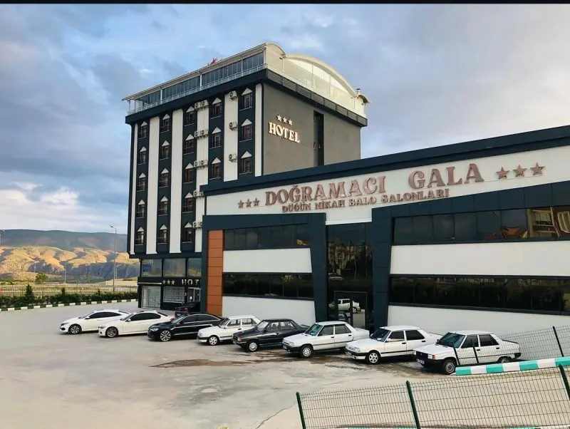 The hotel's daytime exterior with the parking area in front