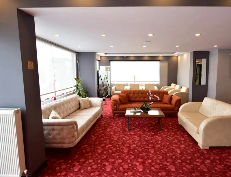 The hotel seating area with cream and orange sofas and a red carpet