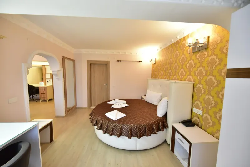 Suite Room: round bed with a brown cover and an arched passage