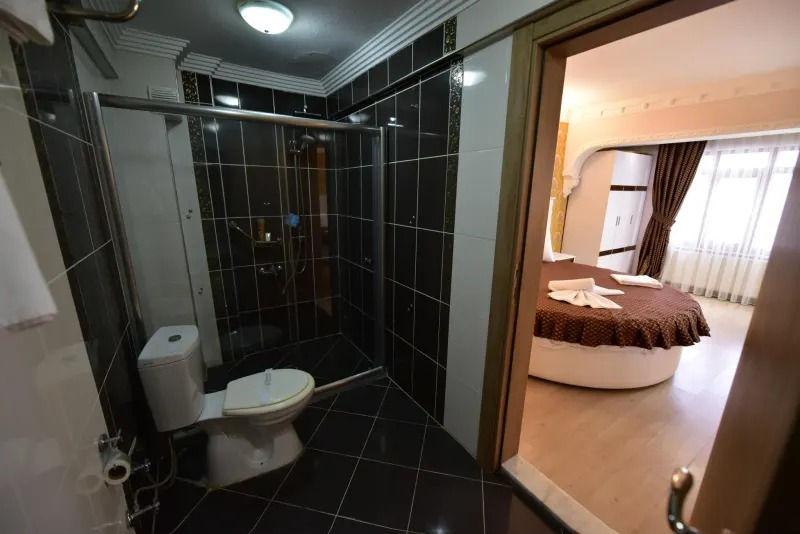 Suite Room: bathroom with black tiles and a glass shower enclosure